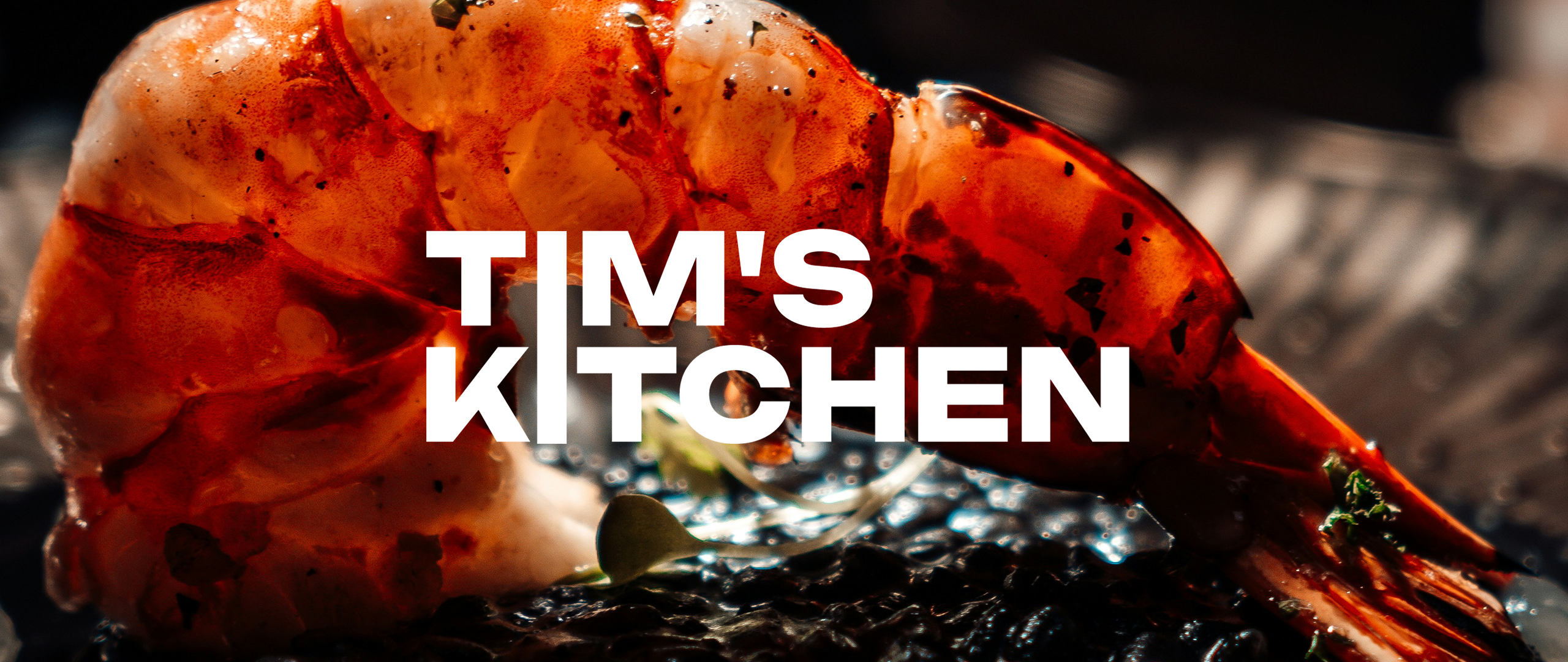 Close Up Bild einer Garnele und darüber das Logo von TIM'S KITCHEN
